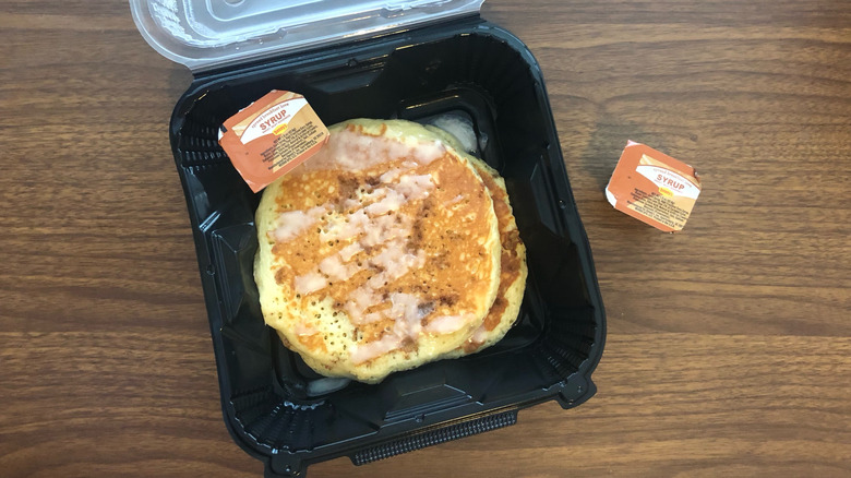 Denny's cinnamon roll pancakes in to-go box.