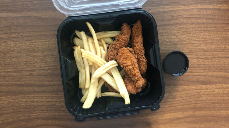 Denny's chicken tenders and fries meal in to-go box.