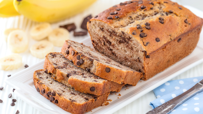 Sliced chocolate chip banana bread on white serving plate