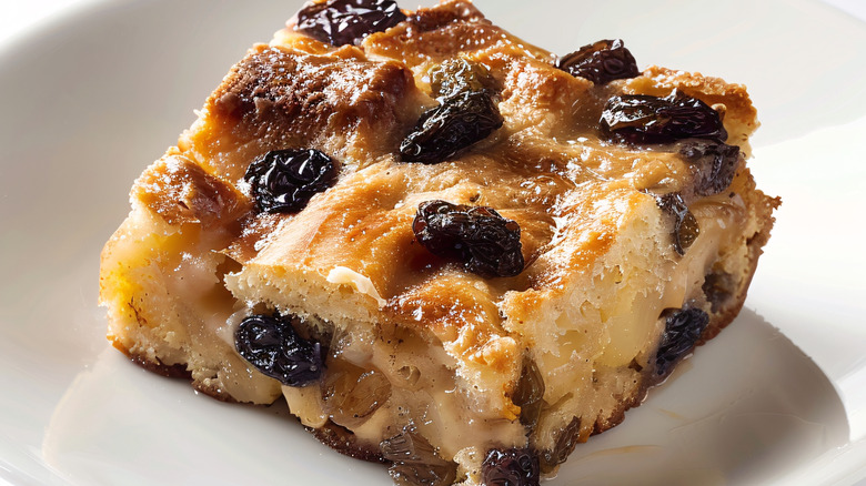 Slice of old-fashioned bread pudding with raisins on plate