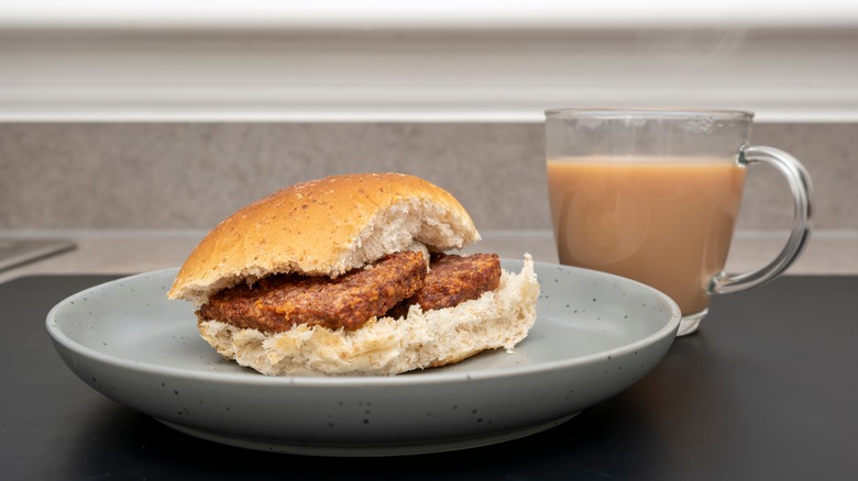 Lorne sausage bap on a plate with mug of milky coffee