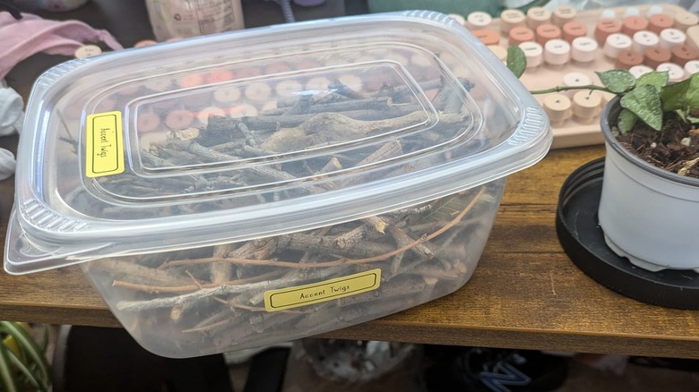 Cold cut container on a table filled with twigs labeled as accent twigs