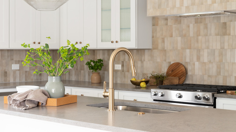 Kitchen faucet detail against a grey kitchen island