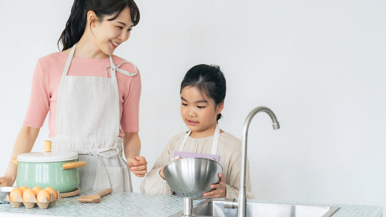 Mother and daughter cooking together at a kitchen island