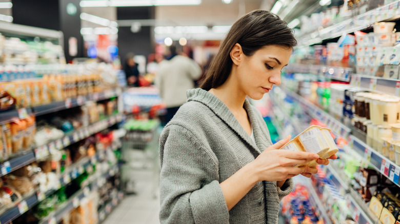 Woman at the grocery store checking prices and ingredients