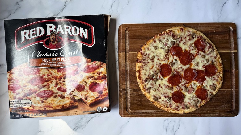 Red Baron Classic Crust Four Meat pizza box next to pizza on cutting board