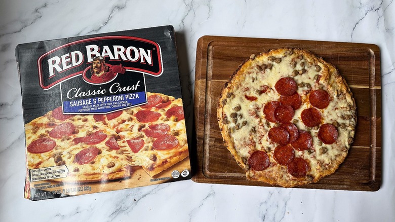 Red Baron Classic Crust Sausage Pepperoni pizza box next to pizza on cutting board