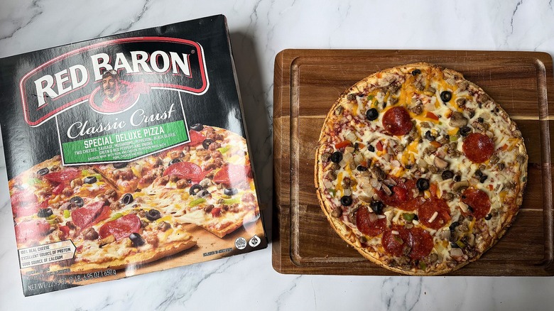 Red Baron Classic Crust Special Deluxe pizza box next to pizza on cutting board