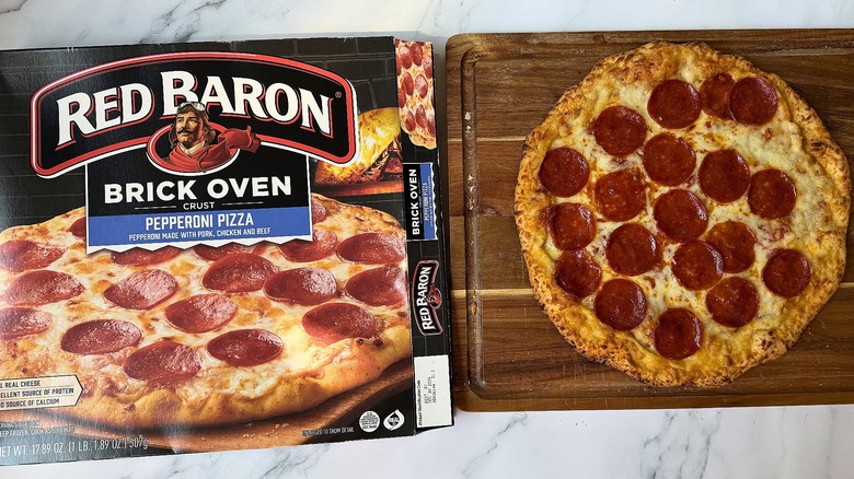 Red Baron Brick Oven Pepperoni pizza box next to pizza on cutting board