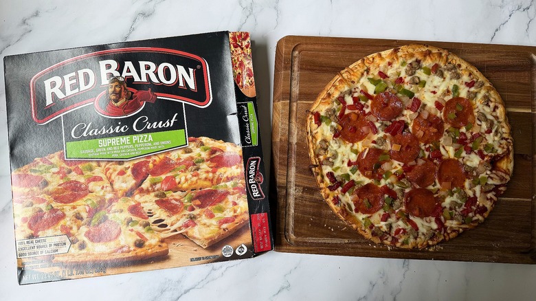 Red Baron Classic Crust Supreme pizza box next to pizza on cutting board