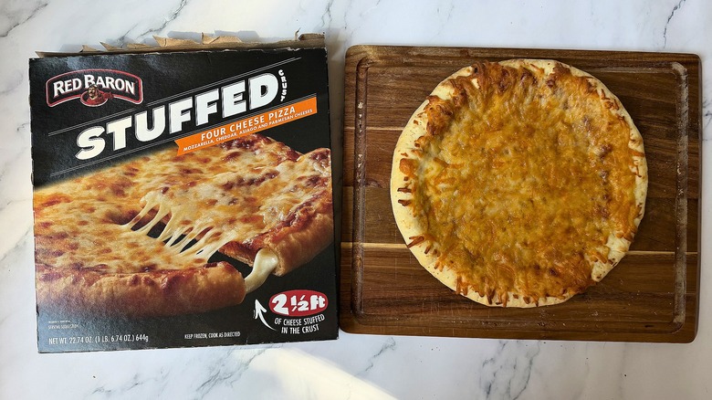 Red Baron Stuffed Crust Four Cheese pizza box next to pizza on cutting board