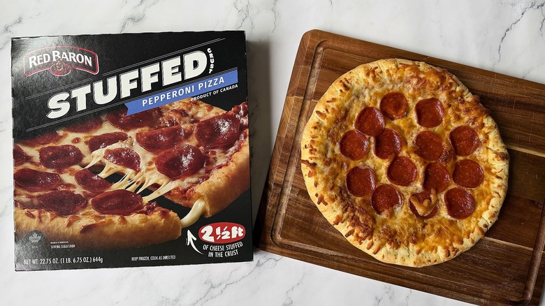 Red Baron Stuffed Crust Pepperoni pizza box next to pizza on cutting board
