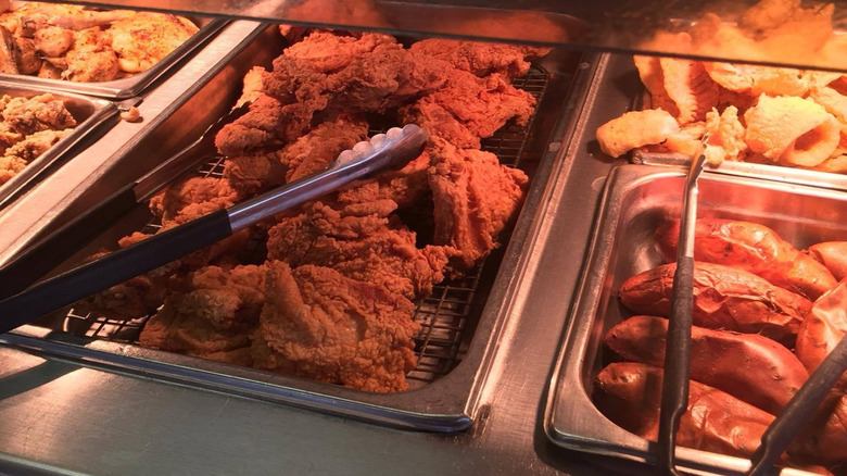 Fried chicken and other food items in trays at the buffet station
