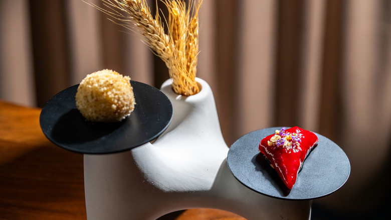 Gourmet amuse-bouche dishes placed on artisanal plates