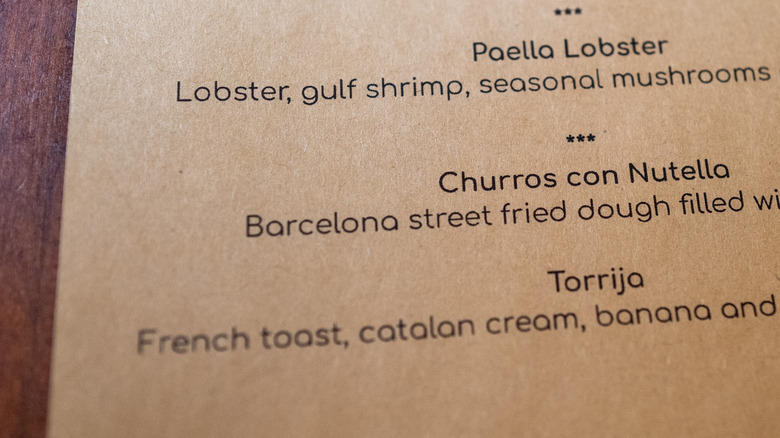 Close-up shot of a restaurant menu placed on a wooden table