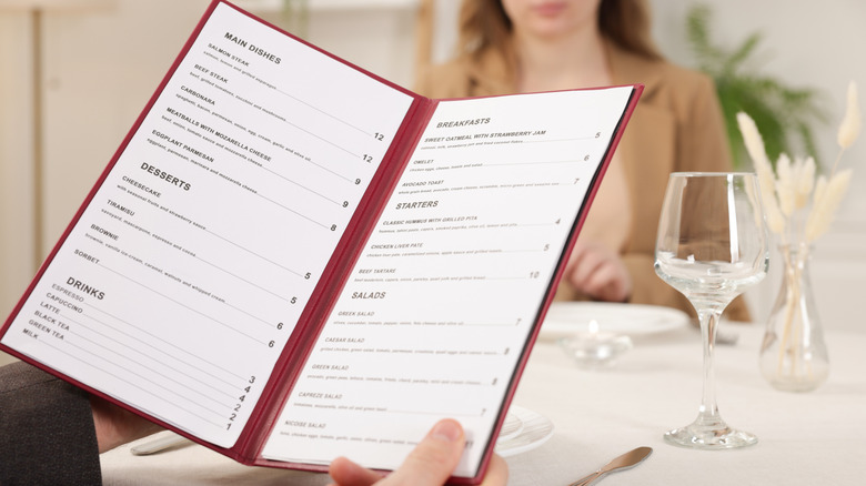 Man holding a menu at a restaurant