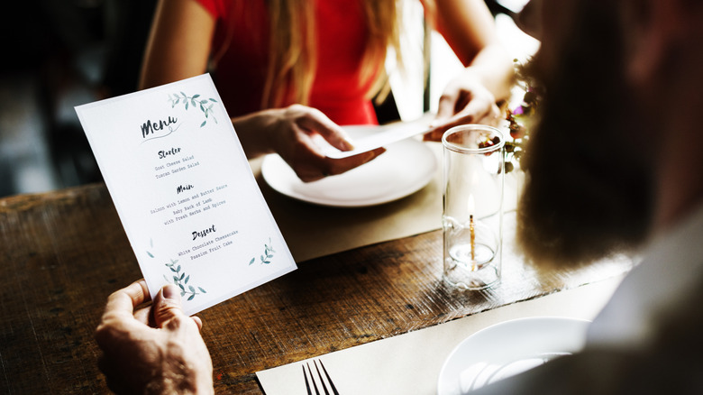Man holding a menu at a restaurant