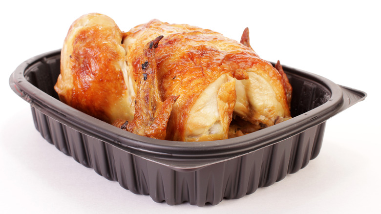 Pale rotisserie chicken in black to-go container
