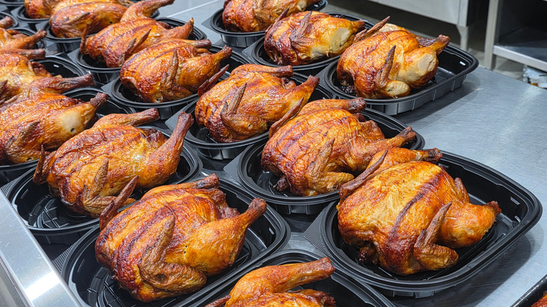 Grocery store rotisserie chickens in black to-go containers