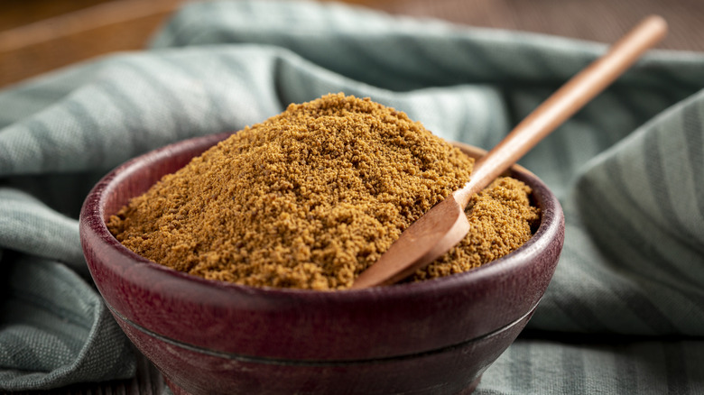 Garam masala in a bowl with a wooden spoon