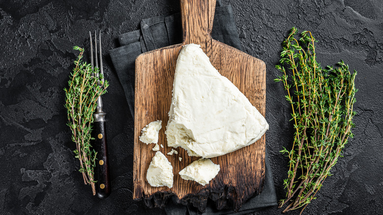 Soft goat cheese on a cutting board with thyme