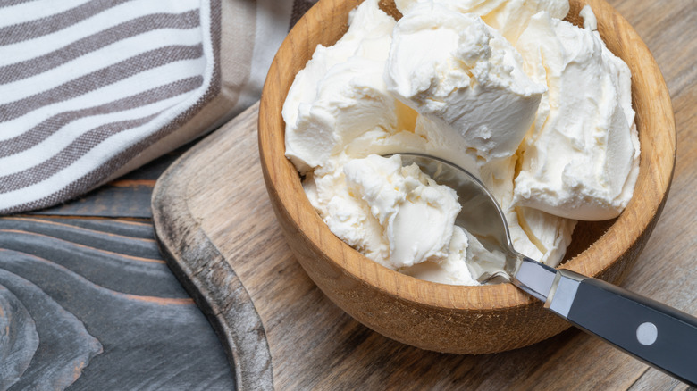 Fresh mascarpone in a wooden bowl on kitchen counter