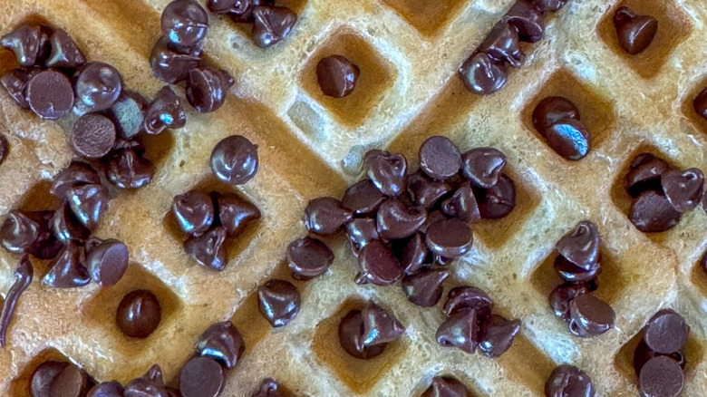 Chocolate chips sprinkled on a cooked waffle