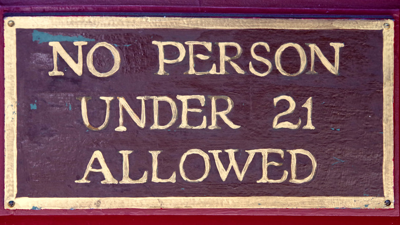 A bar sign saying, "No person under 21 allowed"