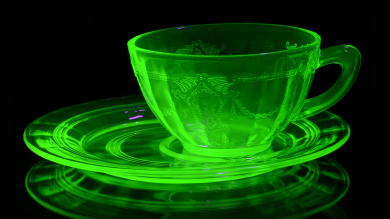 Uranium glass cup and saucer glowing green under black light