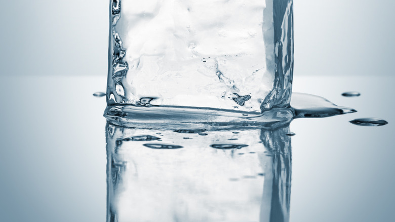 A melting ice block on a silver surface