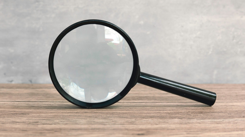 A magnifying glass on a wooden counter