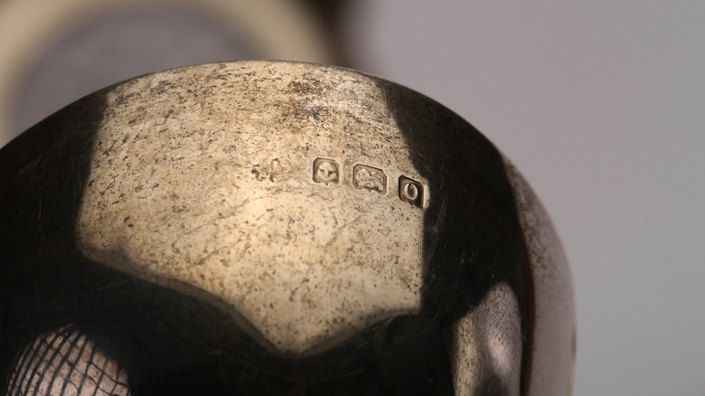 A close up of silverware with unique hallmarks