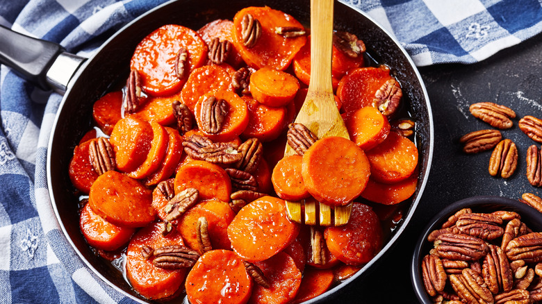 A pan full of candied sweet potatoes with pecans
