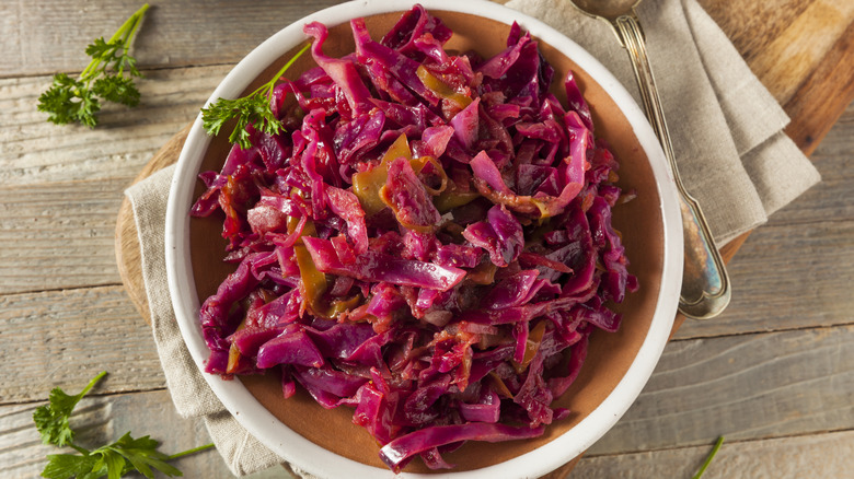 Braised red cabbage in serving dish, topped with sprig of parsley