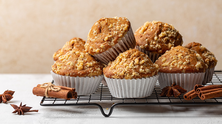 Cinnamon streusel muffins piled on wire cooling rack