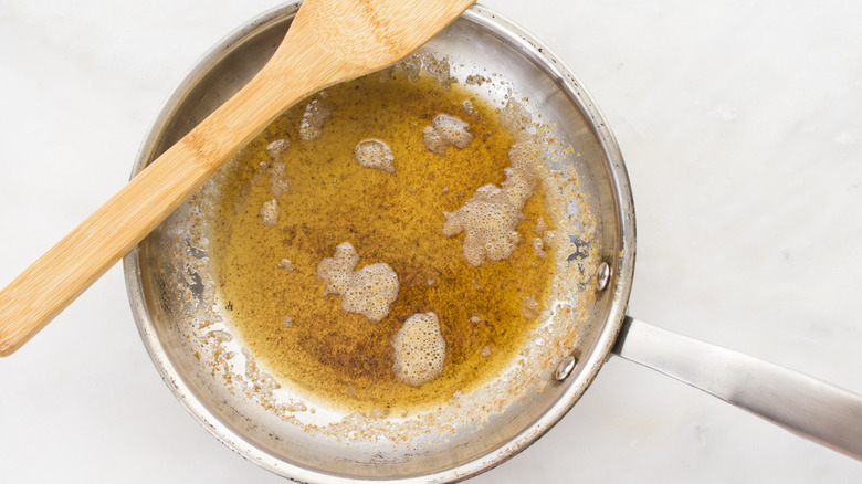 Brown butter in stainless steel skillet with wooden spatula resting on top