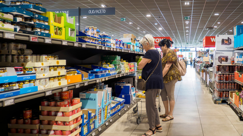 Shoppers comparing prices of products at Aldi