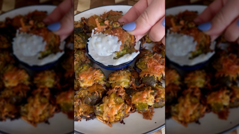 Dipping crispy smashed Brussels sprouts into creamy dip
