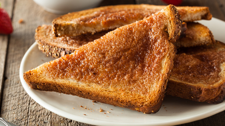 Sugar and Cinnamon Toast slices on white plate on wooden surface