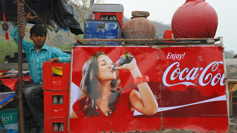 Indian street vendor next to Coca-Cola sign