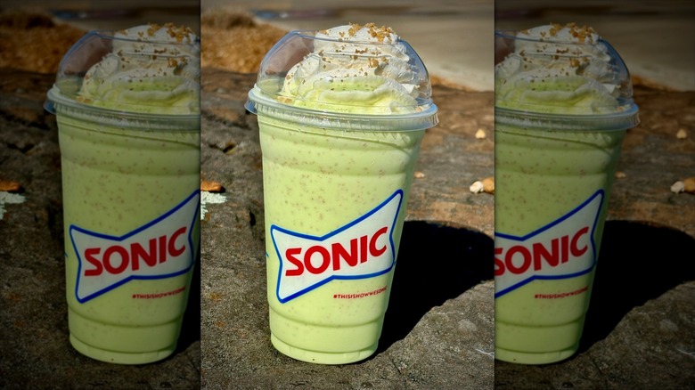 Key lime pie shake placed outside on rock