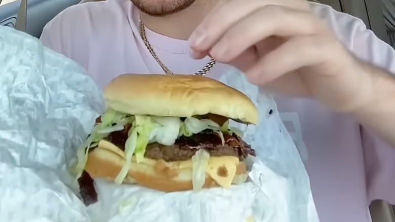 Customer in car trying Sonic's Ring Leader Loaded Burger