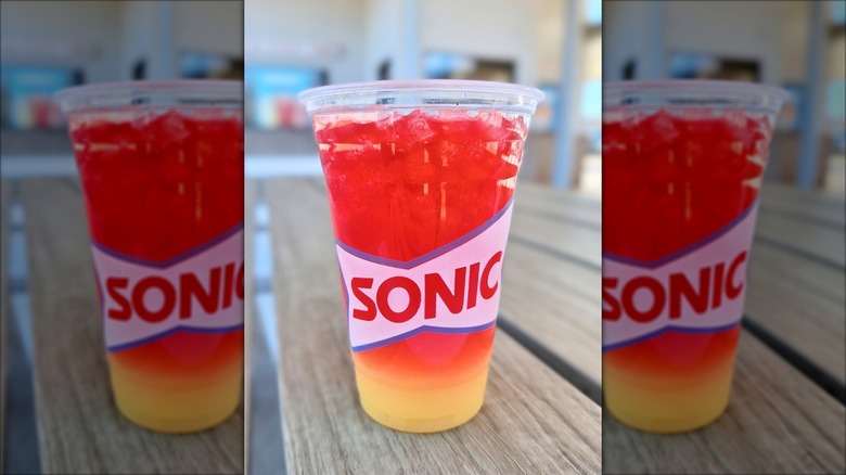 Sonic Sunrise drink in clear cup on outdoor wooden table