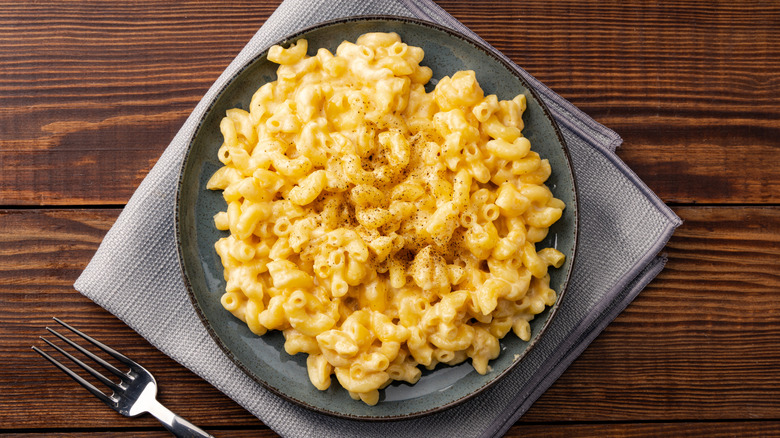 A bowl of macaroni and cheese placed on a grey napkin
