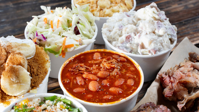 Several side dishes including baked beans, coleslaw, and potato salad