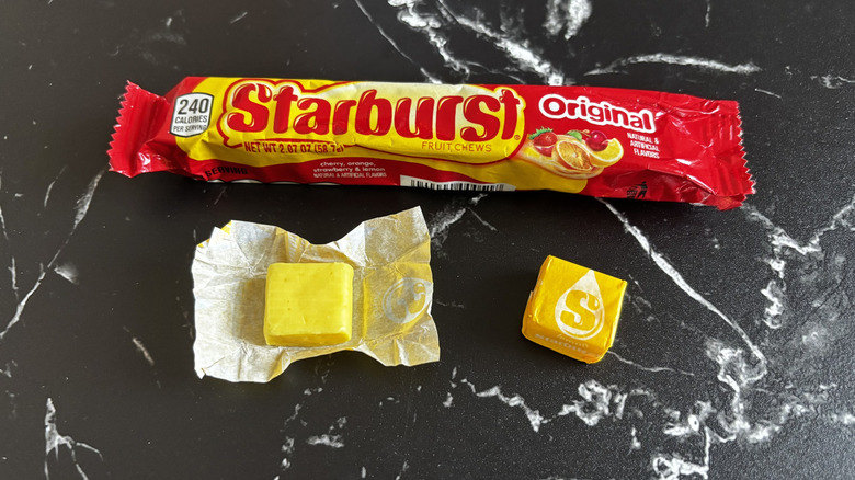 Starburst candy package next to wrapped and unwrapped lemon Starburst