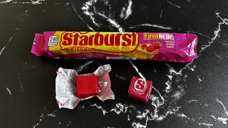 Starburst candy package next to wrapped and unwrapped fruit punch Starburst