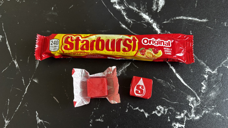 Starburst candy package next to wrapped and unwrapped cherry Starburst