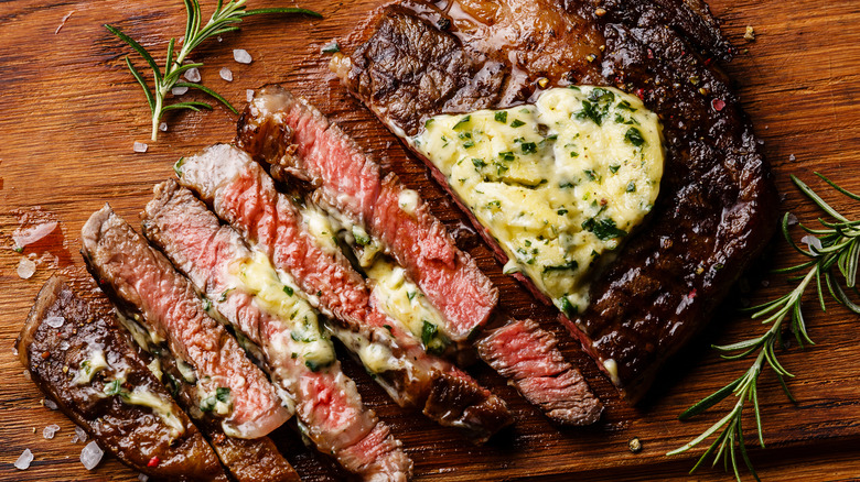 sliced grilled steak topped with herbed butter and salt