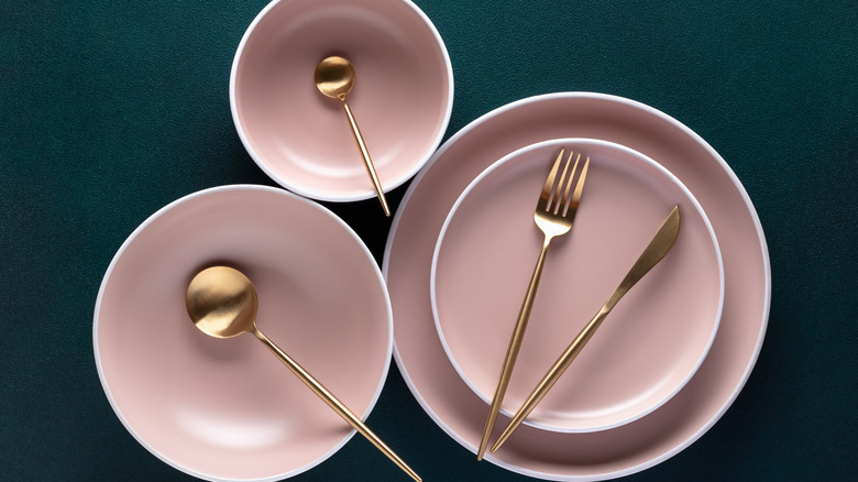 Crockery and golden cutlery on a dark green background